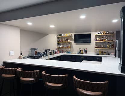 Basement bar area with wraparound white countertops in a Plain City, OH renovation