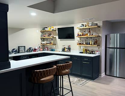 Basement kitchenette with bar seating and built-in storage in Plain City, OH