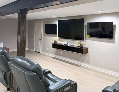 Basement media wall with mounted TVs and custom beam detail in Plain City, OH